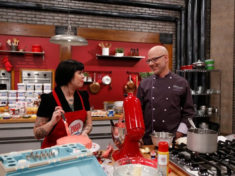 Guest Chef Ron Ben-Israel of Food Netowrk's "Sweet genius" checks in with Red Team recruit Crystal Lonneberg as she prepares her variation of a Basic Vanilla Cake with Swiss Meringue Buttercream Frosting that he demonstrated earlier. Chef Ron gave the recruits very specific directions to follow as a basis for their own unique cakes. Crystal is calling her cake "Winter in Paris." It's flavored with Vanilla Extract, Almonds, Chocolate, and Expresso, as seen on Food Network's Worst Cooks in America, Season 4.