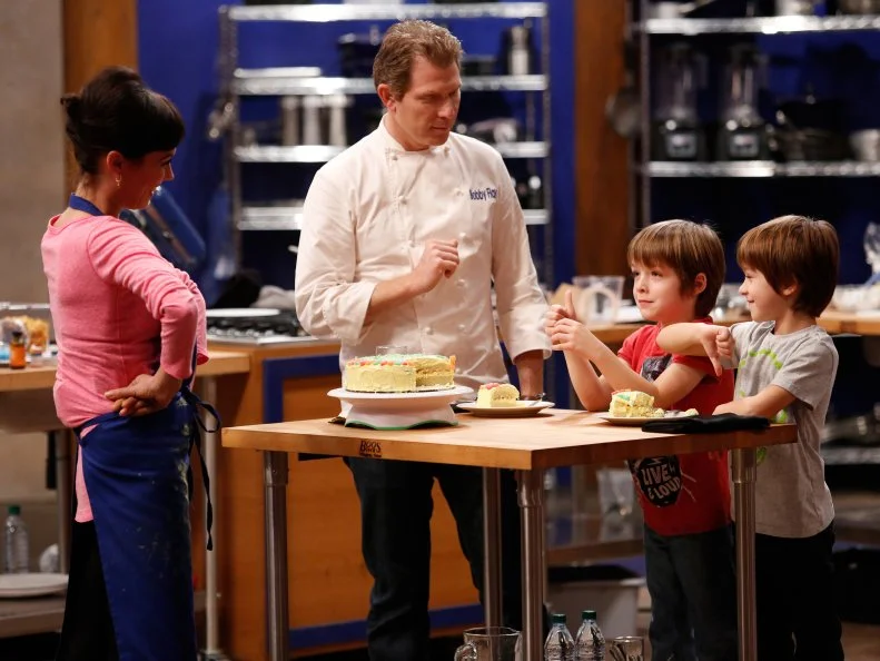 Blue Team Leader Chef Bobby Flay and Guest Judges Sawyer and Dash Dolgins taste the cake Blue Team Recruit Carrie Lee Riggins prepared to celebrate their 7th Birthday in the Cake Bake off Challenge.  Carrie prepared a Vanilla cake with lemon buttercream frosting with rice crispies in between the layers.  She decorated the cake with sour gummi candies and colored icing. Recruits had to prepare their version of a Basic Vanilla Cake with Swiss Meringue Buttercream Frosting demonstrated by Chef Ron Ben-Israel. Chef Ron gave the recruits very specific directions to follow as a basis for their own unique cakes, as seen on Food Network's Worst Cooks in America, Season 4.