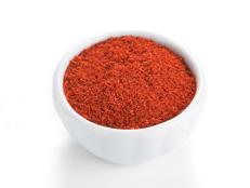 Paprika ground in a bowl on white background.