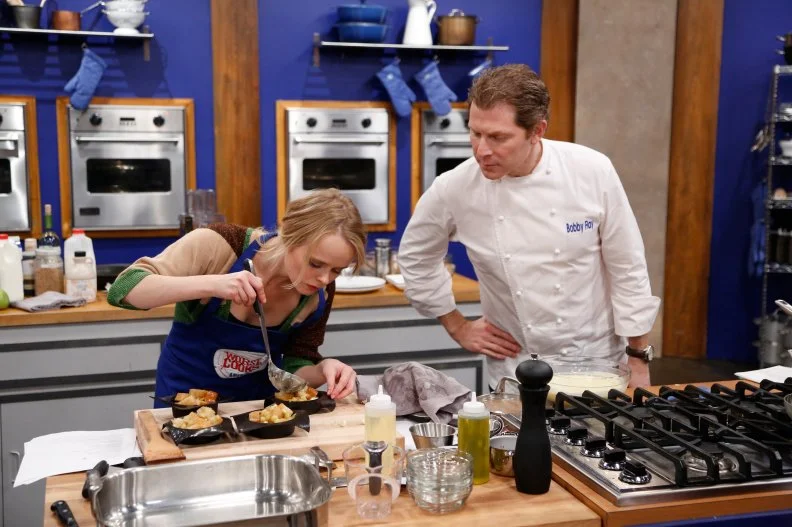 Blue Team Leader Chef Bobby Flay coaches Blue Team Finalist Alina Bolshakova during the final skill drill: a practice run of her finale menu and Alina's final chance to learn from Chef Bobby before she must prepare this meal with no hands on help from Chef Bobby. They are starting with her desert course so the bread pudding can cook while she prepares the rest of the meal.
Alina's menu is:
Appetizer -
Lobster Scampi over Creamy Polenta with Garlic Chips
Main Dish -
Spice Rubbed Pork Tenderloin with Roasted Brussels Sprouts, Jalapeno Pesto and Pomegranates, and hazelnuts.
Dessert -
Granny Smith Apples and Ginger Bread Pudding with Vanilla Bean Creme Anglaise
 At the final cook off Alina must represent her team leader Chef Bobby Flay and prepare a three course restaurant-quality meal for a panel of distinguished chefs and food critics.  Only one winner will take home the $25,000 prize, and Chef Bobby is confident Alina will be the first Blue Team winner, as seen on Food Network's Worst Cooks in America, Season 4.