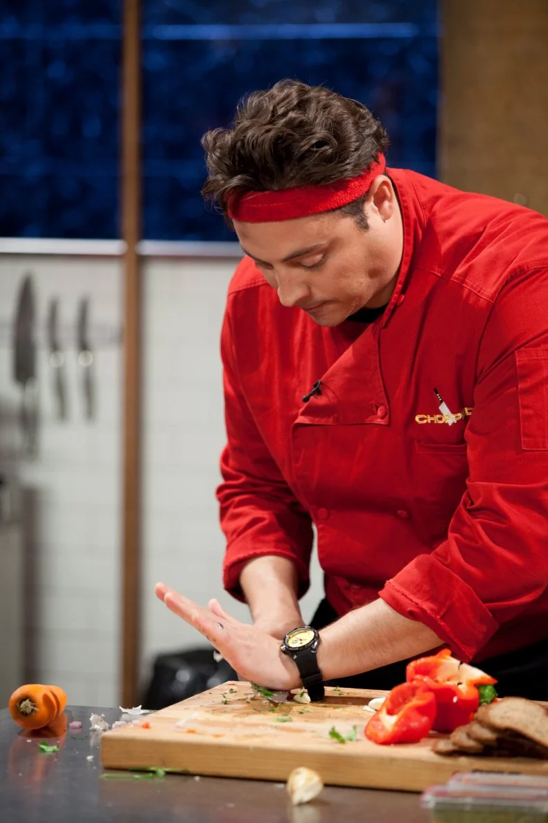Chef Jeff Mauro crushes garlic, as seen on Food Network’s Chopped All Stars, Season 14.

