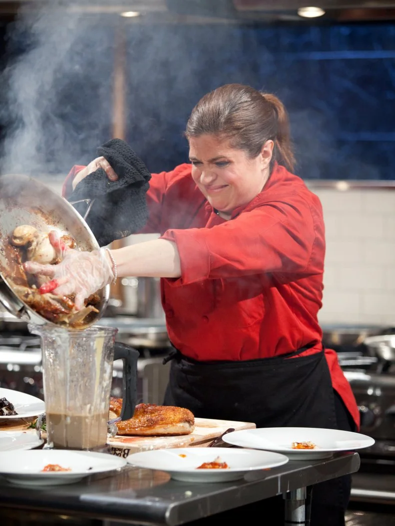 Judge and Chef Alex Guarnaschelli pours the juices in her pan into the sauce in her blender, as seen on Food Network’s Chopped All Stars, Season 14.