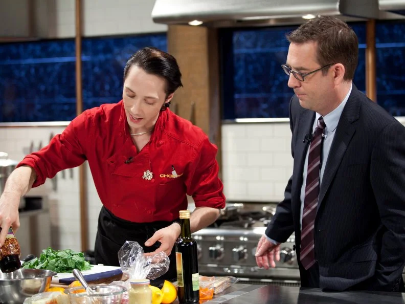 Host Ted Allen checks in with figure skater Johnny Weir, as seen on Food Network’s Chopped All Stars, Season 14.

