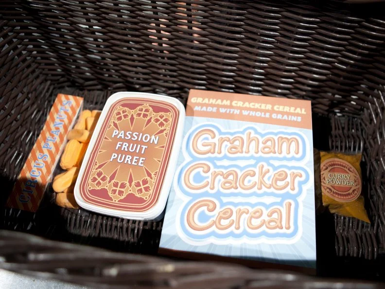 Basket ingredients for the dessert round, including circus peanuts, passion fruit puree, graham cracker cereal, and curry powder, as seen on Food Network’s Chopped All Stars, Season 14.
