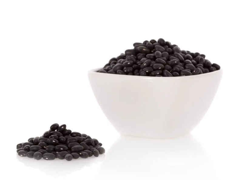 Black turtle beans in a bowl isolated on white