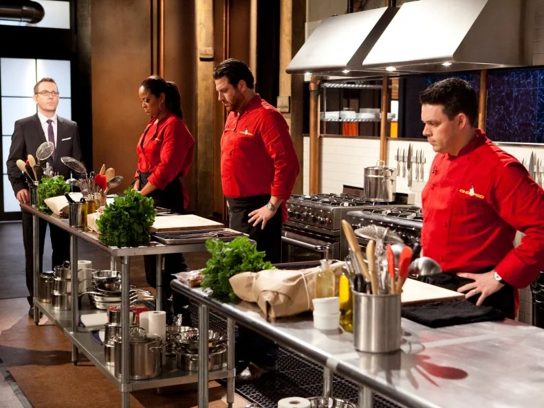 Host Ted Allen instructing All-Star Chefs: Laila Ali, Scott Conant and Gavin Kaysen as they begin to make their entree's which must include: suckling goat, broccoli rabe, farro and cheddar filled pretzels ,as seen on Food Network's Chopped All-Stars, Season 14.