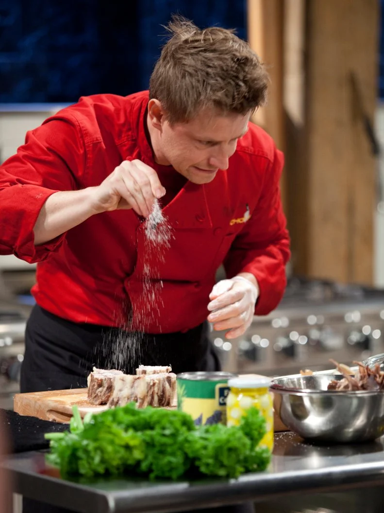 Chef Richard Blais seasons meat, as seen on Food Network’s Chopped All Stars, Season 14.
