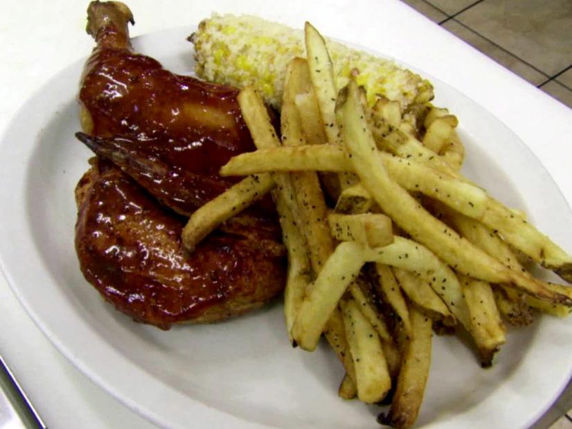 Bbq glazed smoked chicken with corn on the cob and fries.