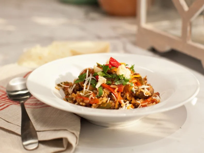 A bowl of Chicago Gumbo (Italian sausage, green and red peppers, and onions sautÂ©ed with smoked paprika, red wine and mixed with cooked white rice. Garnished with giardiniera and grated aged provolone) as seen on Food Network's The Kitchen, Season 1.