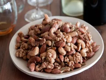 You know what makes a little get-together even more special? Sweet and spicy roasted nuts. It’s a quick and simple recipe that is a really nice touch when you’re welcoming people into your home. Plus, making them ahead of time makes your house smell welcoming, and your neighbors might start wandering over to see what’s going on in your kitchen!

Since I’m the only one in my family that has been to culinary school, I’m typically the one that’s always in the kitchen working on whatever is for dinner. But, these sweet and spicy nuts are so easy that I can delegate them to my husband to put together. The best part is, he feels like he has been super helpful in the kitchen! You can use your favorite assortment of nuts, but I prefer a combination of cashews, walnuts, almonds and pepitas. I use egg whites and water to create a natural binding effect on the nuts with the spice mixture consisting of Spice Islands salt, cayenne pepper and ground cinnamon. The sweet and spicy flavors make for an interesting but welcome surprise as a pre- or post-dinner snack!