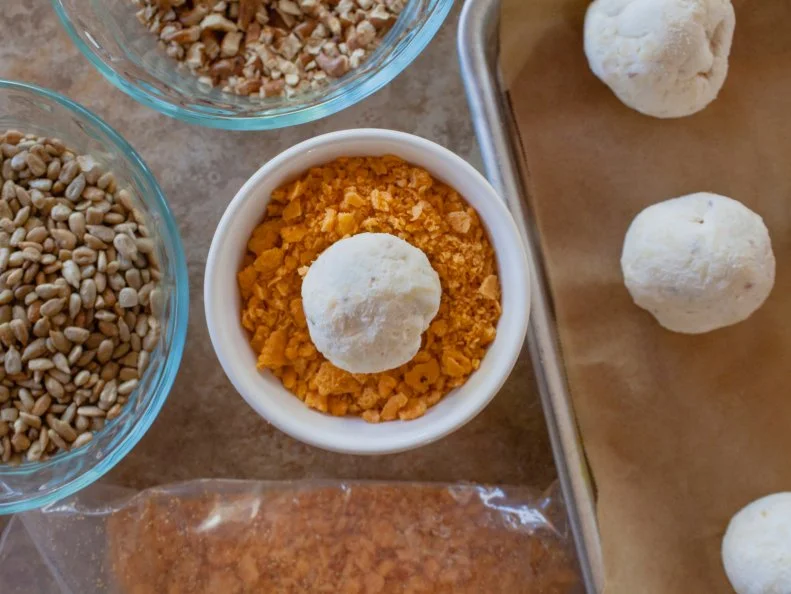 Roll chilled mini cheese balls in savory or sweet toppings to coat.