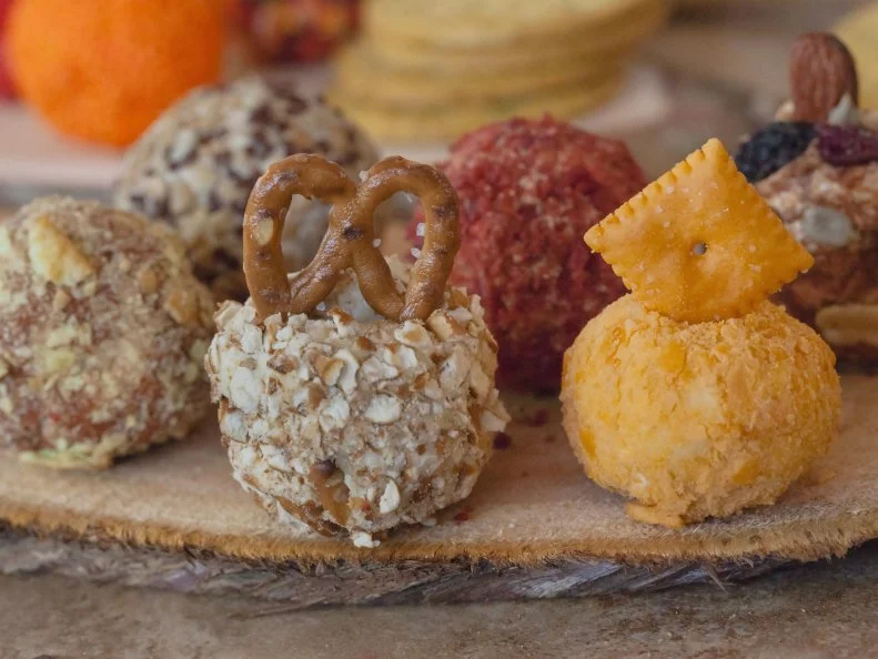 Mini savory cheese balls rolled in pretzel chips, cheese-its, bacos, sunflower seeds.