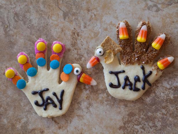 Hand cookie place cards decorated with sprinkles and candy, by Kids for Thanksgiving.