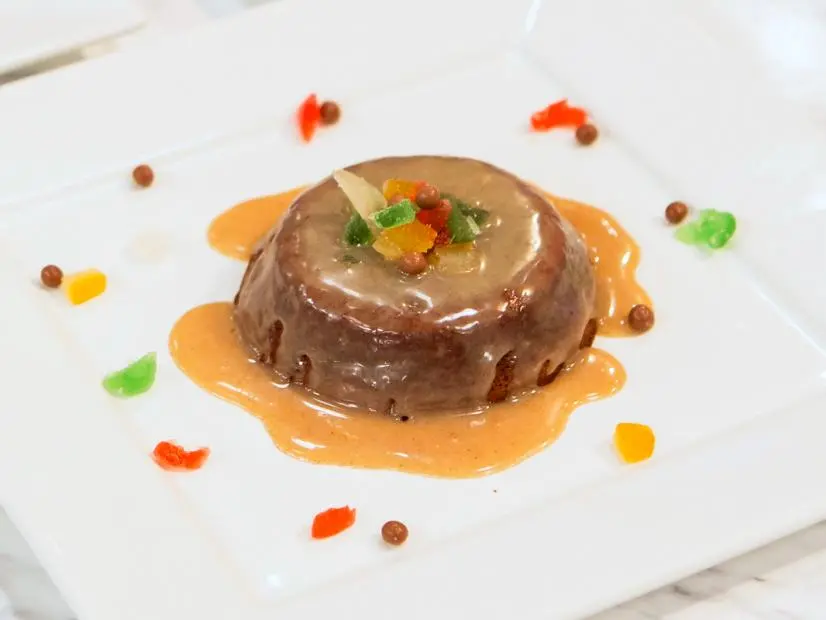 Final plated dish of Fruitcake Junkyard Brownie with a spiced orange liqueur and white chocolate glaze of the Great Holiday Cake-Over preheat challenge as seen on Food Network’s Holiday Baking Championship,
Season 1