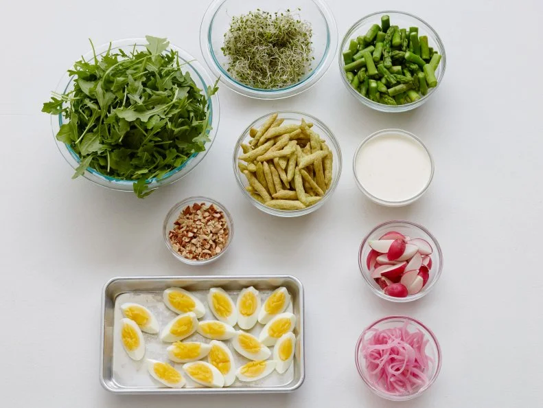 SPRING LAYERED SALAD WITH ASPARAGUS AND BUTTERMILK DRESSINGFood Network KitchenRed Onion, White Wine Vinegar, Asparagus, Buttermilk, Parmesan Cheese, Mayonnaise,Garlic, Baby Arugula, Radishes, Broccoli or Alfalfa Sprouts, Freeze Dried Snap Peas orGreen Beans, Eggs, Almonds