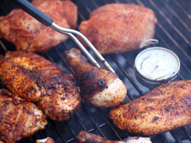 thermometer fork pieces of chicken cooking on grill