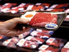 Woman holding packet of beef in supermarket