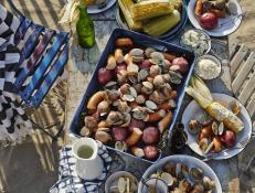 Whether you’re vacationing in New England or elsewhere, summer is the time for an authentic, sea-soaked clambake on the beach.