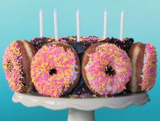 Cake decorated with sprinkles and full sized donuts