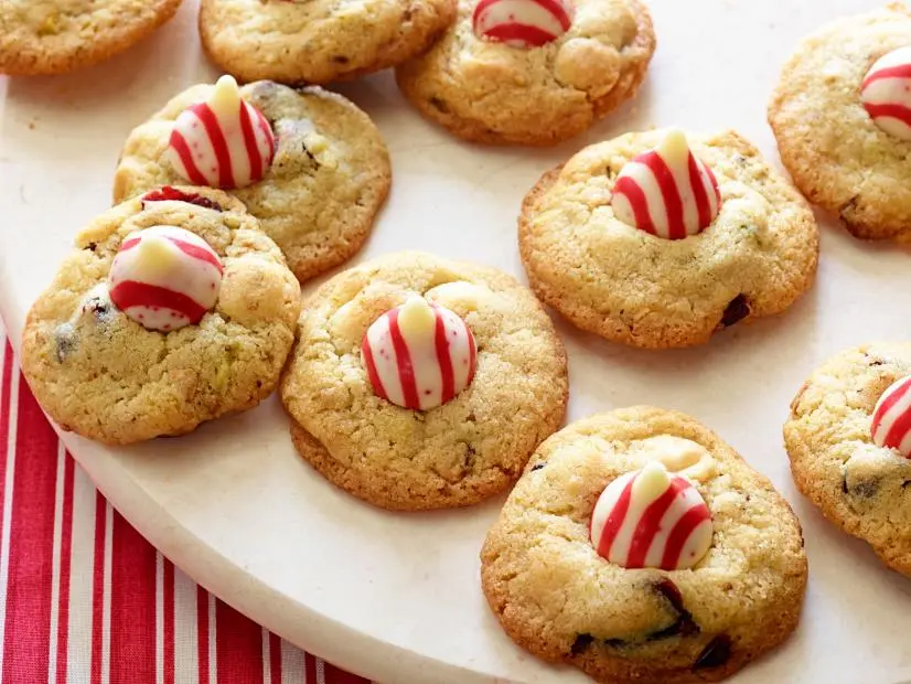 MACADAMIAALMONDCHRISTMAS COOKIESNancy FullerFood NetworkMacadamia Nuts, Sugar, Butter, Vegetable Shortening, Eggs, Vanilla Extract, Almond Extract,Flour, Baking Soda, Fine Salt, White Chocolate Chips, Pistachios, Dried Cranberries, NonstickCooking Spray, RedandwhiteStriped Chocolate Kiss Candies