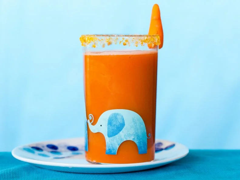 fresh carrot juice garnished with salt, dehydrated carrots and baby carrots
