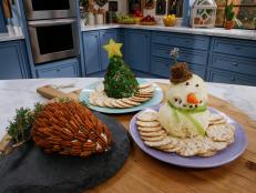 From left, Katie Lee's Pinecone Cheeseball and Tree Cheeseball and Marcela Valladolid's Snowman Cheeseball are seen on the set of Food Network's The Kitchen, Season 8.