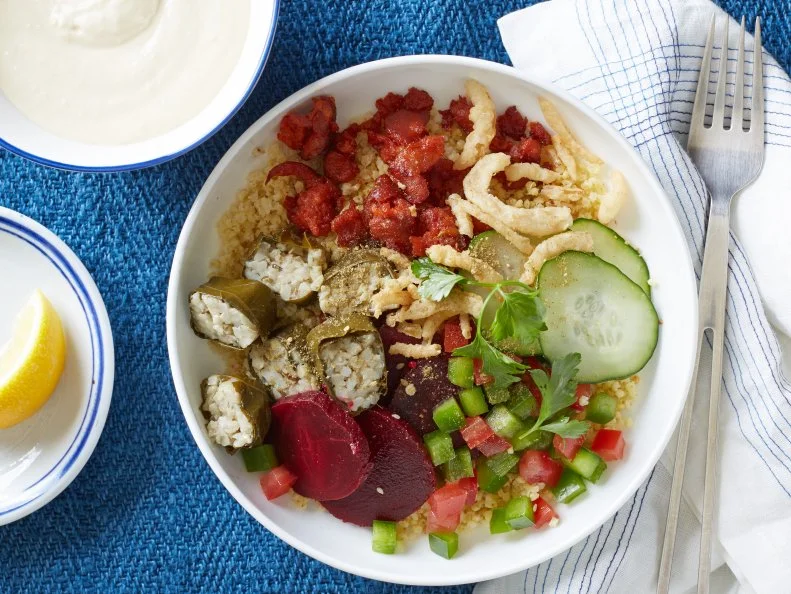 Food Network Kitchen’s millet bowl with stuffed grape leaves and yogurt-hummus sauce as seen on Food Network.