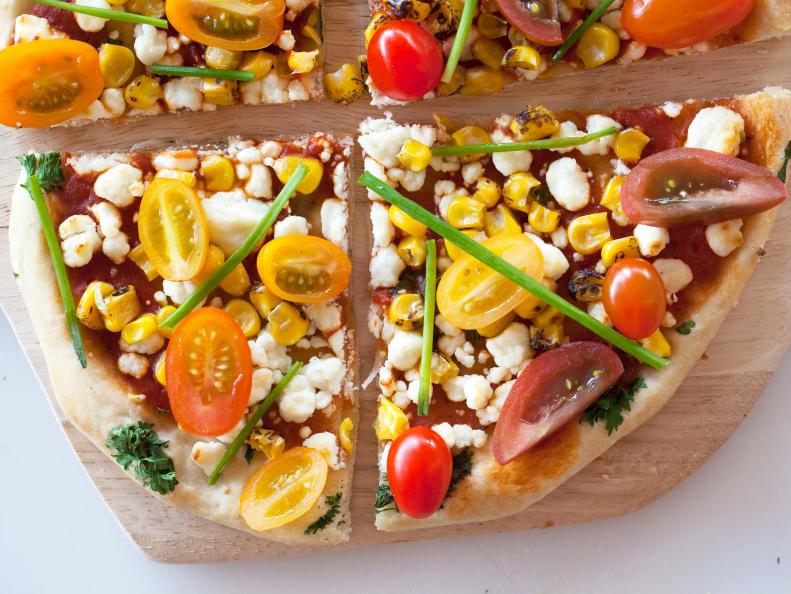 Jackie Alpers' Spring entertaining made easy with Homemade pizza, tomato sauce, goat cheese, roasted corn, heirloom cherry tomatoes, chives, fresh parsley, Recipe and food photography by Jackie Alpers for the Food Network.