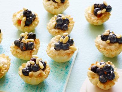 FNK HEALTHY BLUEBERRYRICOTTA
TARTLETS, Food Network Kitchen, Ricotta Cheese,
Apricot Jam, Lemon, Vanilla Extract, Blueberries, Phyllo Cups, Pine Nuts or Sliced Almonds