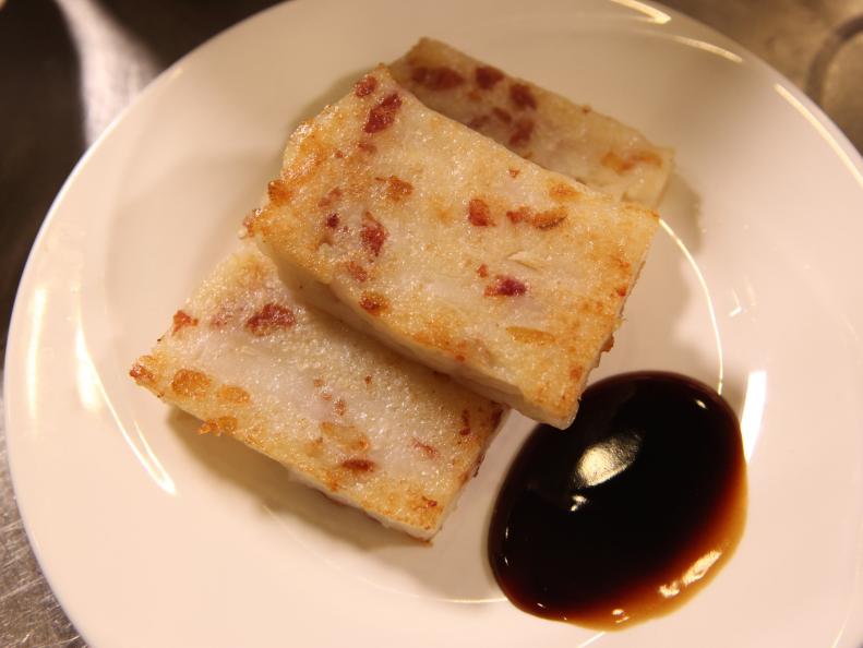 A plate of pan-fried turnip cake served with soy sauce at Jing Fong.