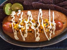 Inspired by Mexican Style Street Corn, this whole beef jumbo hot dog is topped with roasted corn, mayo, lime and spices and served in a top-cut, whole grain bolillo roll. Recipe and photo by Jackie Alpers for FoodNetwork.com