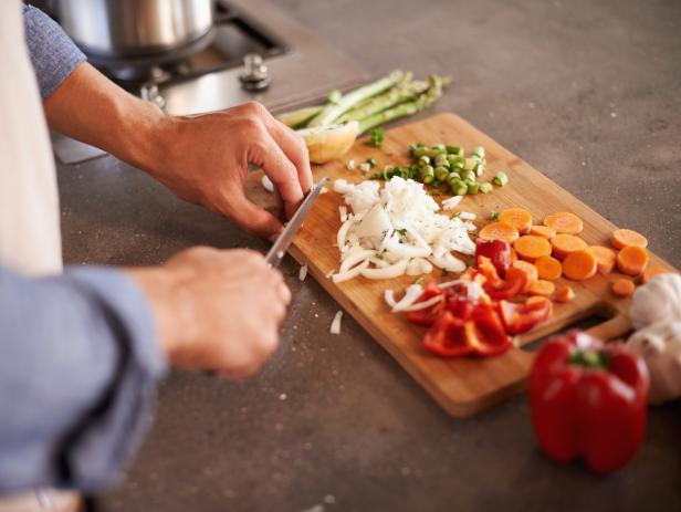 Cropped shot of a man chopping vegetables on a countertop