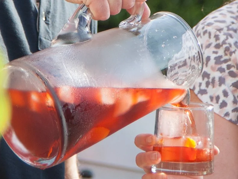 Husband Tom Vitale pours host Valerie Bertinelli a glass of his special Negroni, as seen on Valerieâ  s Home Cooking.