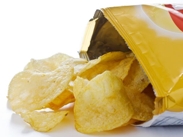 Potato crisp packet opened with crisps spilling out