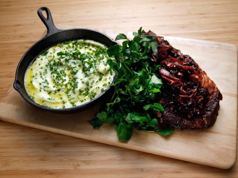 Host Tyler Florence's Pan Seared Rib Eye with French Onion Confit and Pomme Aligot dish is displayed on the set of Food Network's Worst Cooks in America, Season 8.