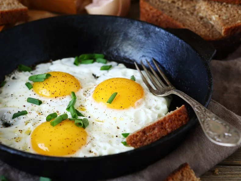 Hot fried eggs in a pan, close up