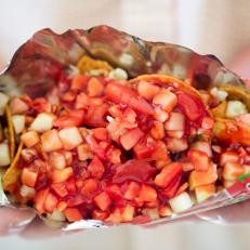 Slice open a bag of Tostidos and fill with chamoy, lemon juice, cabbage, cucumbers tomatoes. One of our iconic Arizona dishes and the restaurants that serve them. Food photography and article by Jackie Alpers for the Food Network.