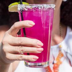 A woman drinking a bright pink prickly pear margarita at Tohono Chul Park Cafe in Tucson. The color is all natural. One of our iconic Arizona dishes and the restaurants that serve them. Food photography and article by Jackie Alpers for the Food Network.