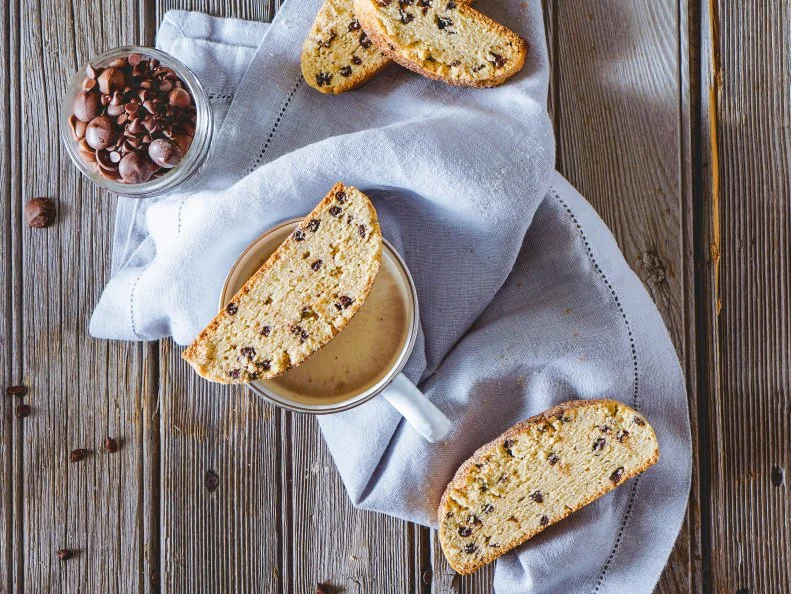 Delicious homemade biscotti or cantuccini with chocolate chips on wooden vintage table, traditional Italian biscuit or cookies. Selective focus, toning.