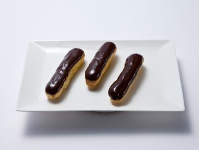 Host Duff Goldmans vanilla cream filled eclair covered in chocolate, as seen on Food Network's Worst Bakers In America, Season 1.