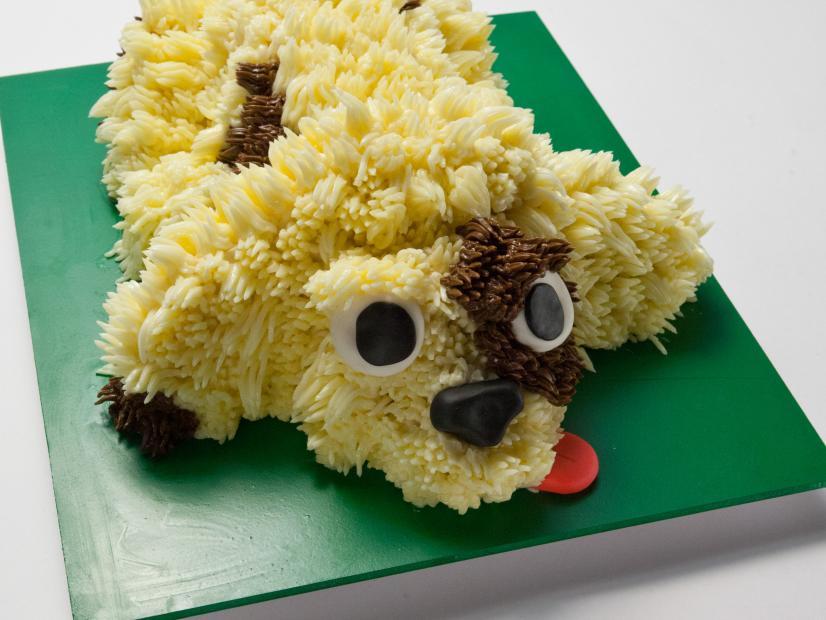 Host Duff Goldman's dog cake made with vanilla butter cream and fondant for the eyes, ears, nose, and tongue, as seen on Food Network's Worst Bakers In America, Season 1.