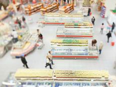 People shopping in a large supermarket shot with a tilt and shift lens with the focus on the racks