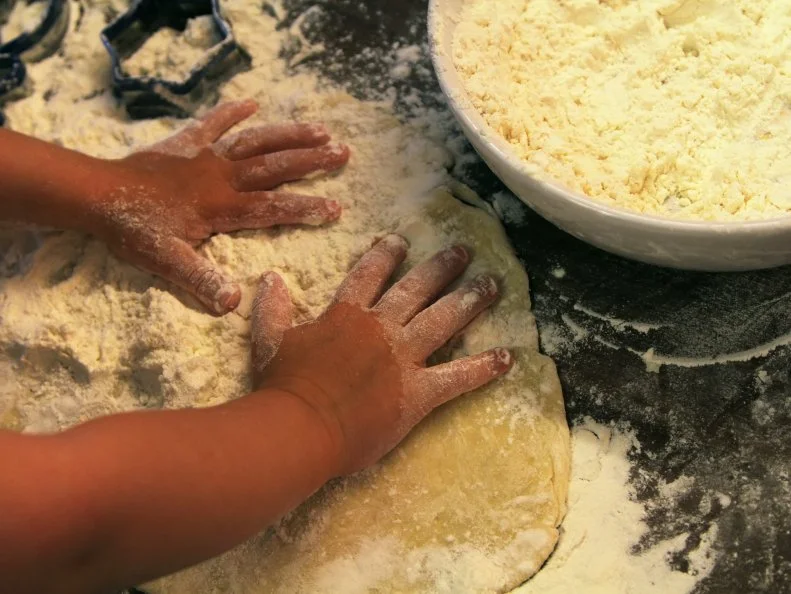Closeup photo of child hands making  dough for cookies . Gastronomy concept