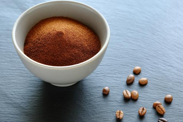 Ground coffee in a bowl, slate background
