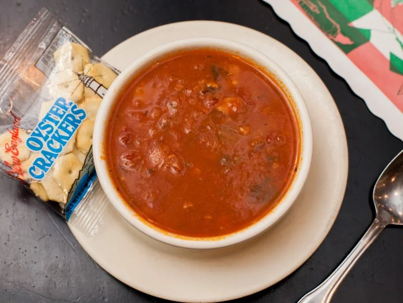 Tomato-based chowders became popular in America in the mid-1800s, as newly arrived tomato-loving immigrants from Italy (in New York) and Portugal (in New England) sarted cooking. What is now referred to as Manhattan Clam Chowder was once called Fulton Market Clam Chowder and Coney Island Clam Chowder. Packed with clams, the best version comes from Brooklyn’s Sheepshead Bay. For a century, Randazzo’s has specialized in Brooklyn-Italian dishes, serving an infamous red sauce and a just-as-popular red chowder. The clam-studded soup is rich and full of zesty flavor.