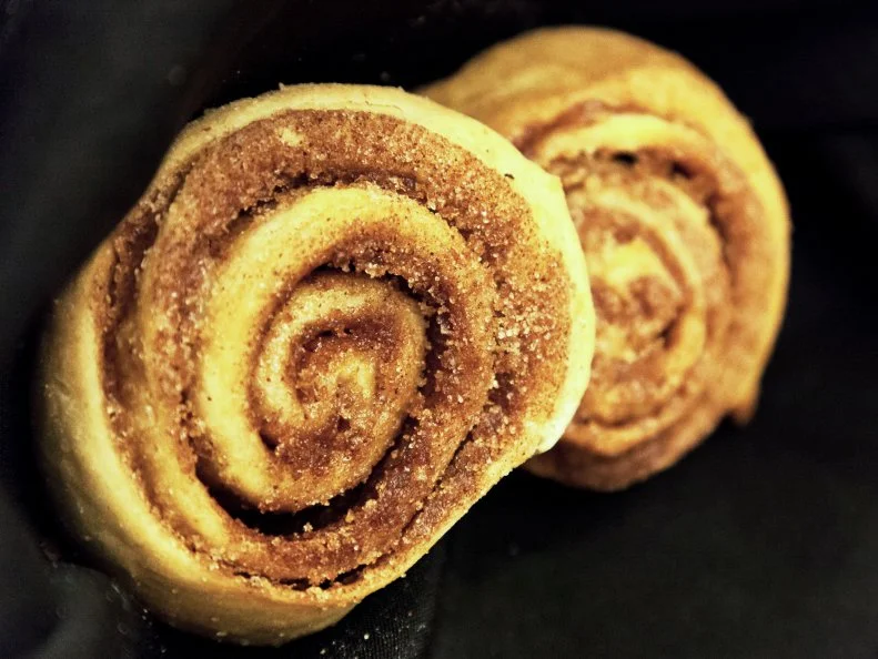 Two cinnamon rolls in a napkin lined basket at Calico County in Fort Smith, Arkansas as included in Arkansas's Most Iconic Eats for FoodNetwork.com