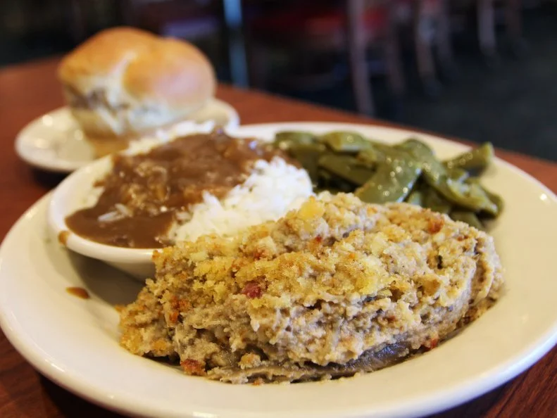 A veggie plate with eggplant casserole, brown gravy on rice and green beans with a roll at Franke's Cafeteria in Little Rock, Arkansas as included in Arkansas's Most Iconic Eats for FoodNetwork.com