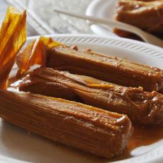 A plate of three Arkansas Delta tamales in their husks at Rhoda's Famous Hot Tamales and Pies in Lake Village, Arkansas as included in Arkansas's Most Iconic Eats for FoodNetwork.com