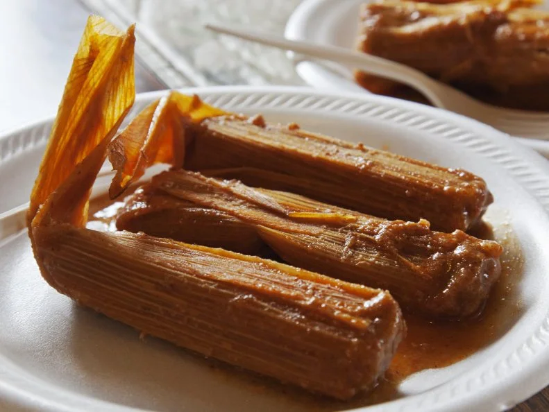A plate of three Arkansas Delta tamales in their husks at Rhoda's Famous Hot Tamales and Pies in Lake Village, Arkansas as included in Arkansas's Most Iconic Eats for FoodNetwork.com