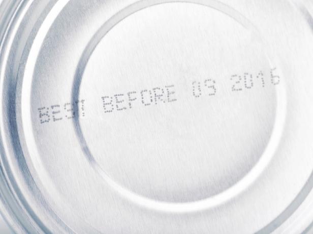 date of expiry  canned food close up: letters and numbers of date of best before on silver colored metal aluminium can,  tin upside down,